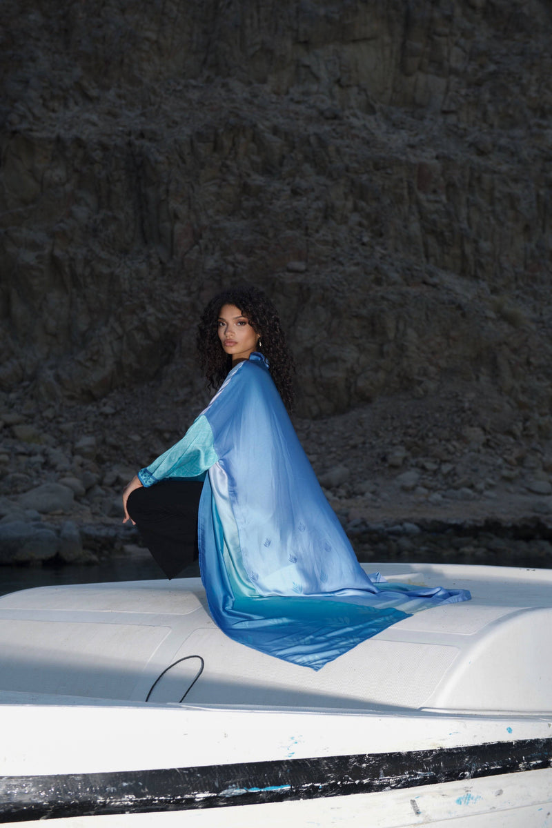 Versatile Indigo Dream Ombré Abaya Set styled on a boat, showcasing its lightweight, matte-shine fabric ideal for contemporary summer fashion.
