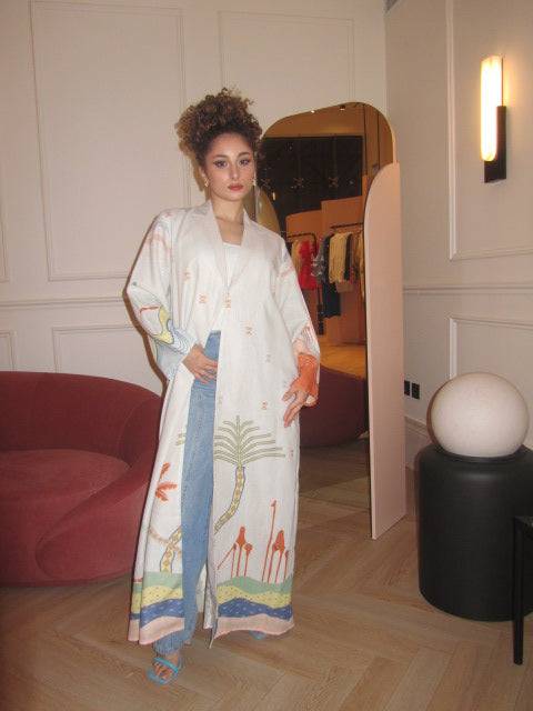 Model poses indoors in The Jeddah Horizon - Abaya & Scarf Set, styled with blue heels and denim for a modern twist.