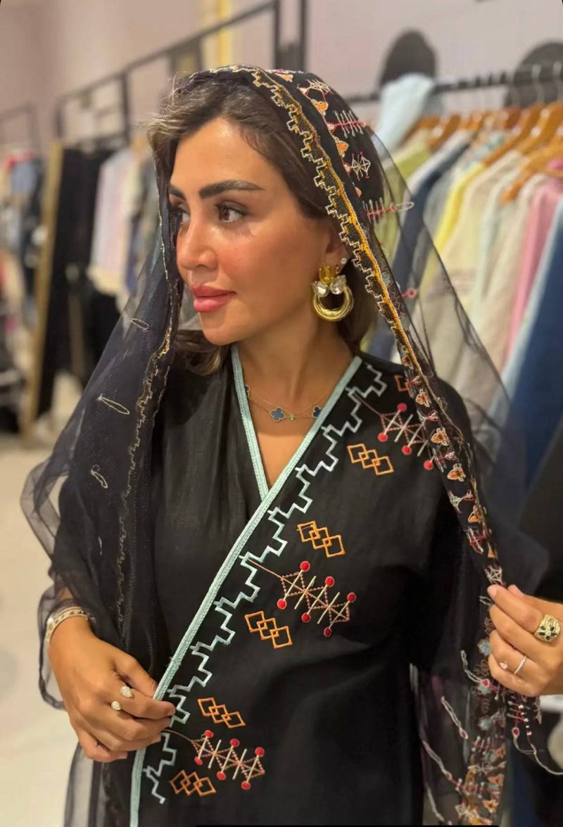 Woman wearing Saudi Abaya & Scarf Set with colorful embroidery, highlighting the fusion of cultural heritage and contemporary fashion.