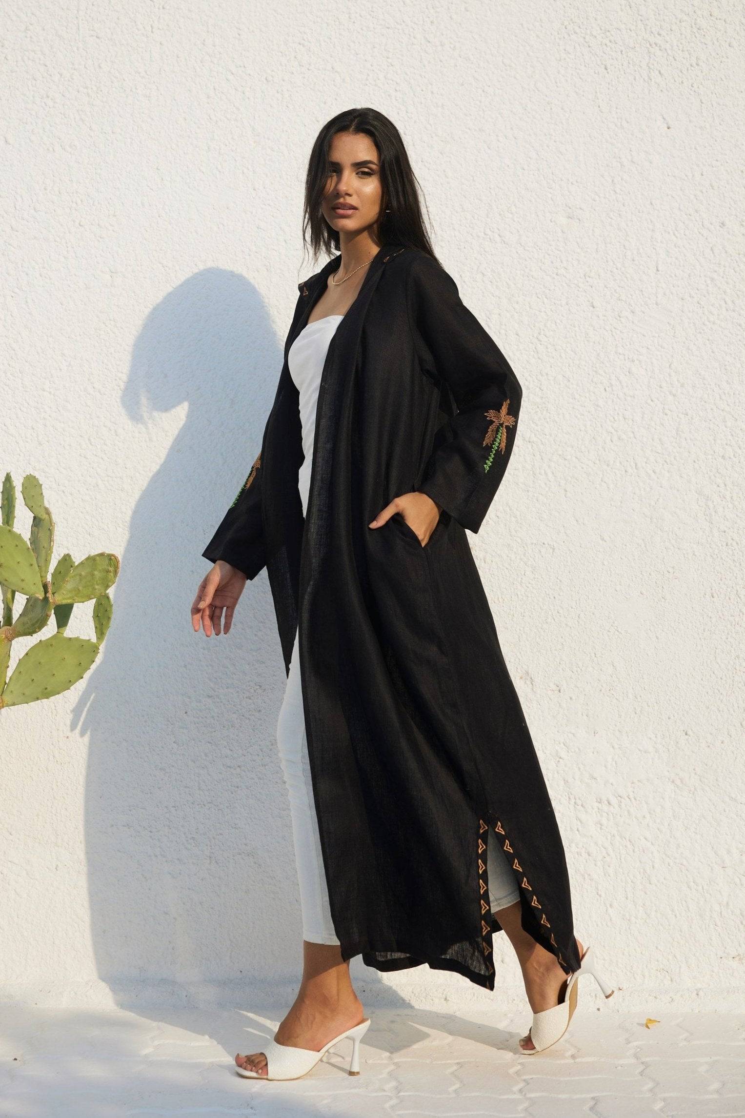 Side view of Nakhla Hoodie Abaya with embroidered sleeves and side slit accents. Designed in breathable organic linen.