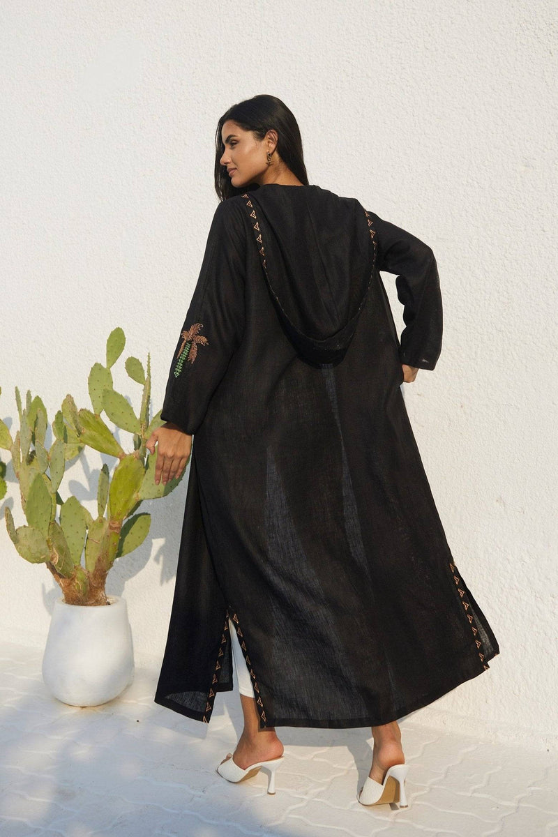 Back view of Nakhla Hoodie Abaya showing hood detail and palm embroidery on sleeves. Crafted from lightweight organic linen.