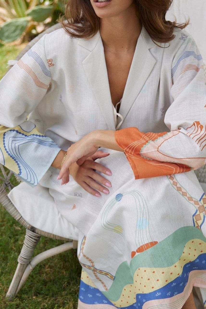 Detailed view of The Jeddah Horizon - Abaya & Scarf Set’s abstract sleeve and skirt prints, styled with gold jewelry.