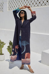 Model poses in The Alula Horizon Blazer Abaya with arms raised, highlighting the vibrant sleeve and hemline designs inspired by Alula heritage.