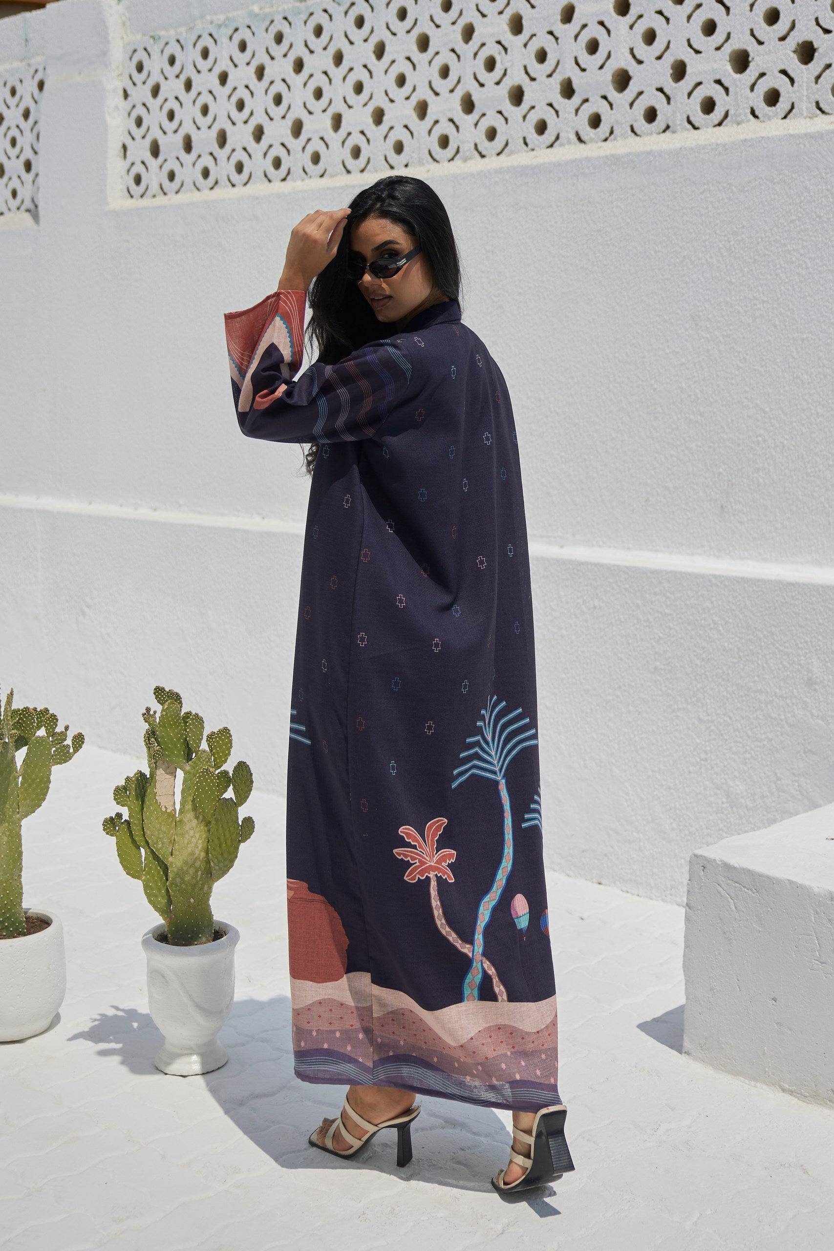 Back view of The Alula Horizon Blazer Abaya showcasing scenic desert artwork and palm trees, crafted in eco-friendly linen fabric.