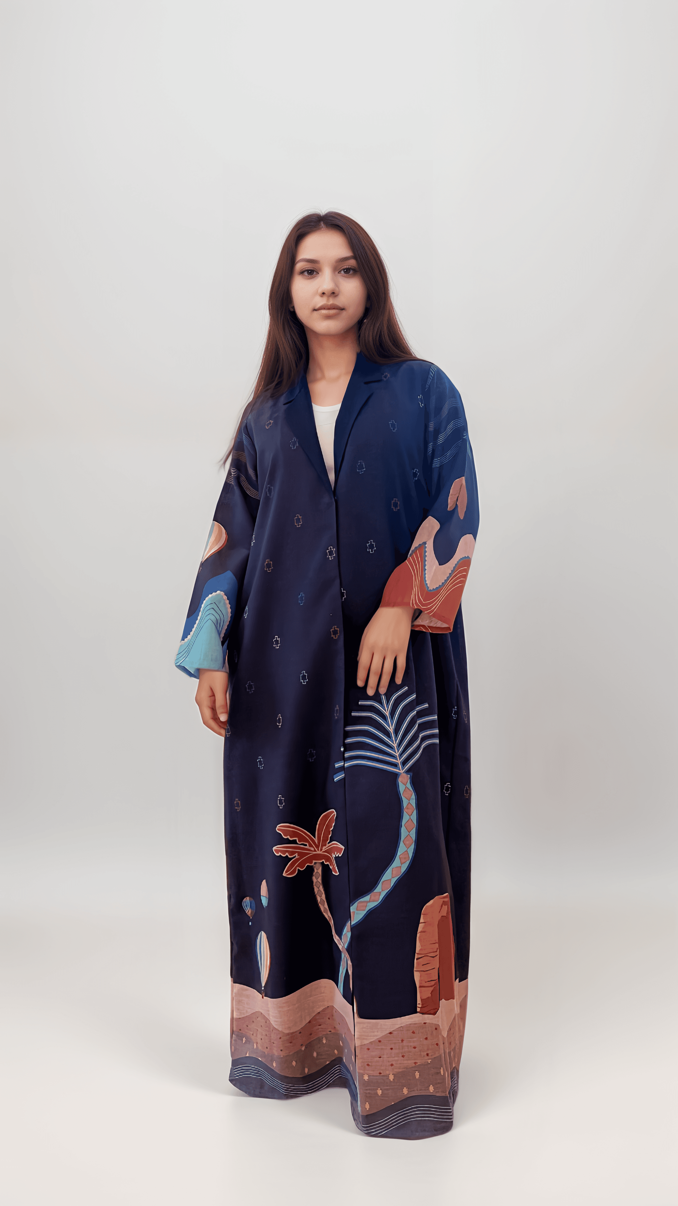 Studio shot of The Alula Horizon Blazer Abaya featuring desert motifs, palm trees, and Elephant Rock on a navy linen base.
