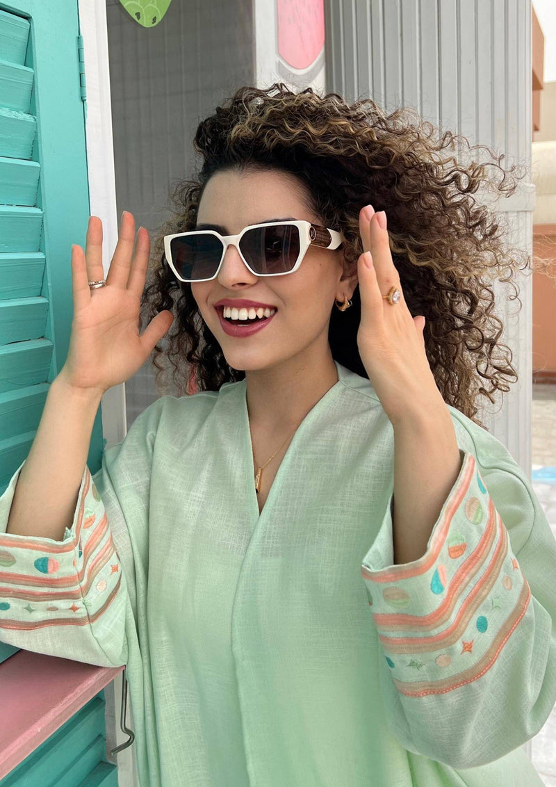 Close-up of Birthday Abaya in cold mint, highlighting colorful embroidered sleeves and breathable summer fabric.