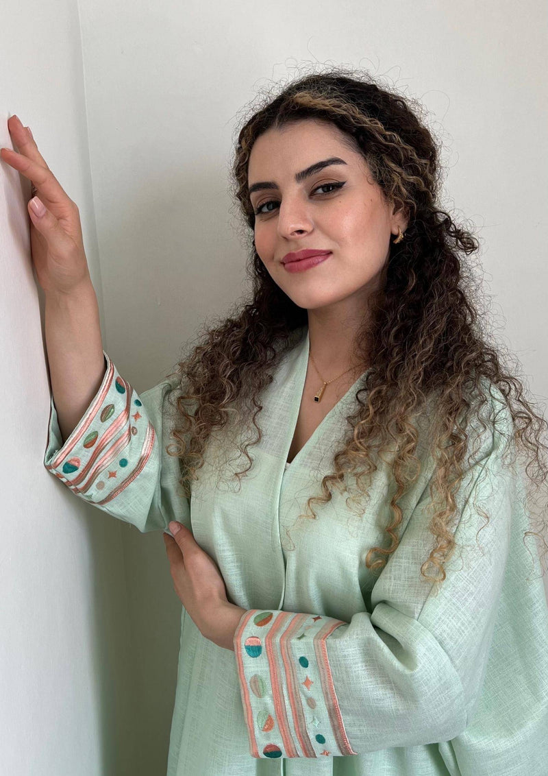 Model in cold mint Birthday Abaya with pastel embroidery, perfect for summer events and traditional fashion lovers.
