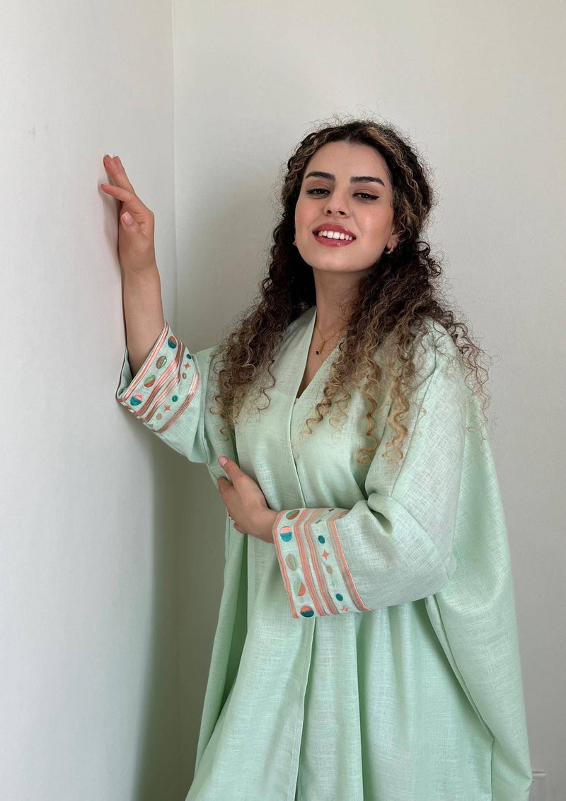 Smiling model in Birthday Abaya & Scarf Set in cold mint, styled for summer with embroidered sleeves and soft fabric.
