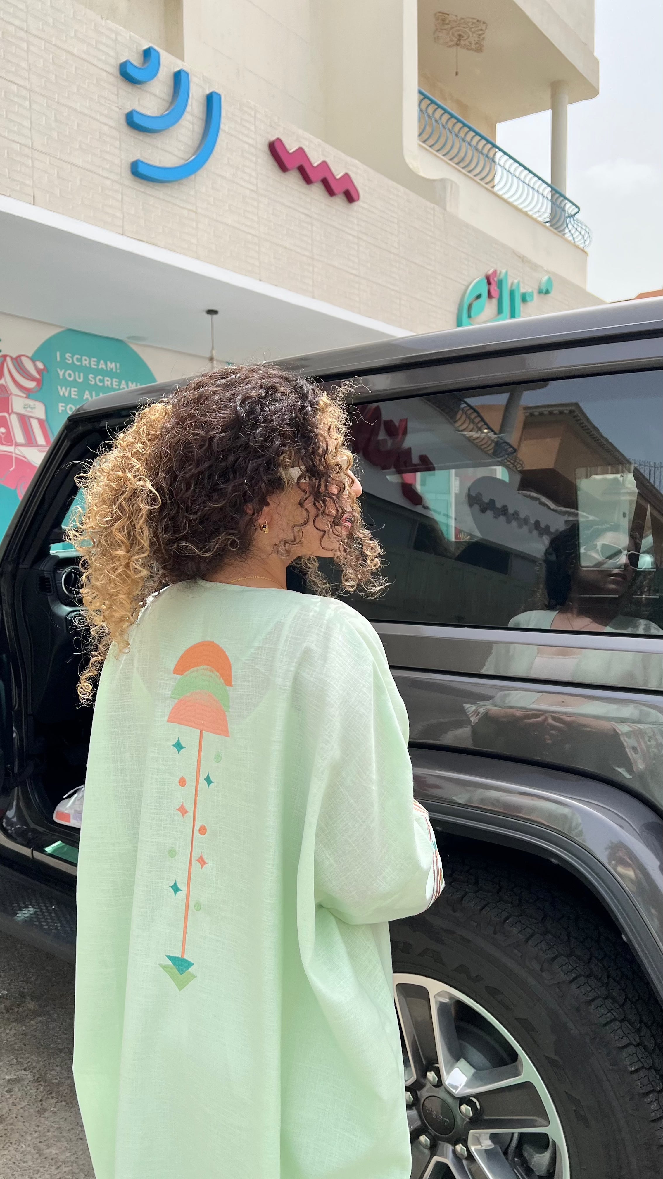 Cold mint Birthday Abaya with geometric back embroidery, styled casually outdoors for a relaxed summer vibe.