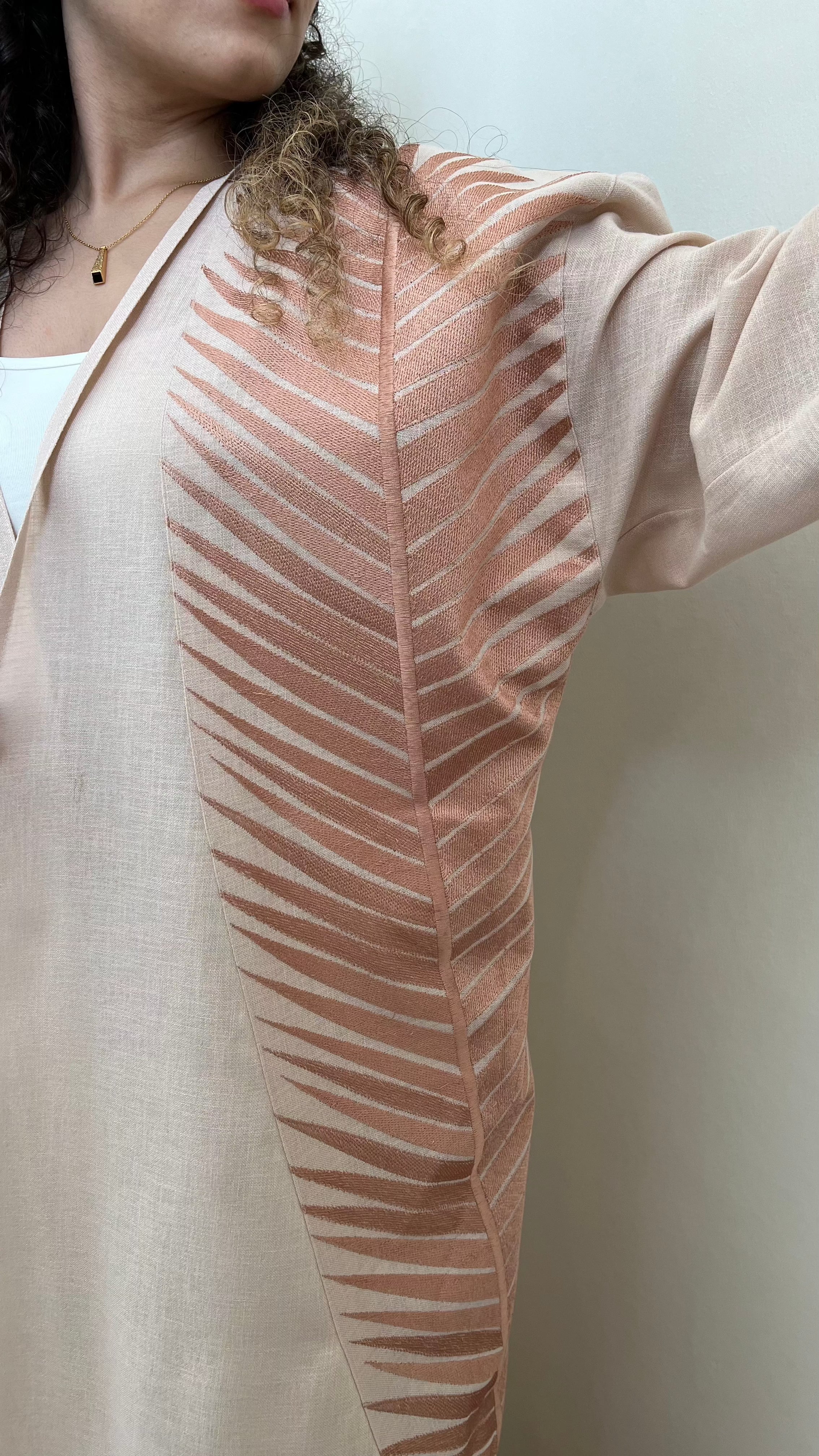 Rosé Gold Abaya - Breast Cancer Awareness | Solidarity, Hope. Close-up of rose gold embroidery on abaya sleeve, representing strength and unity.