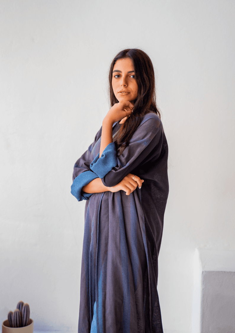 Side view of The WORKaholic Abaya - Daily Wear in grey, highlighting the flowy silhouette and rolled blue sleeves.