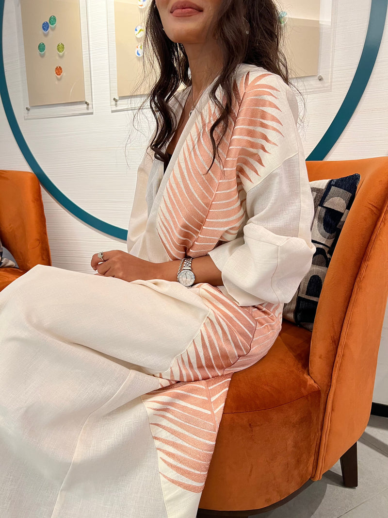 Rosé Gold Abaya - Breast Cancer Awareness | Solidarity, Hope. Seated view highlighting the abaya’s rose gold detailing and luxurious texture.