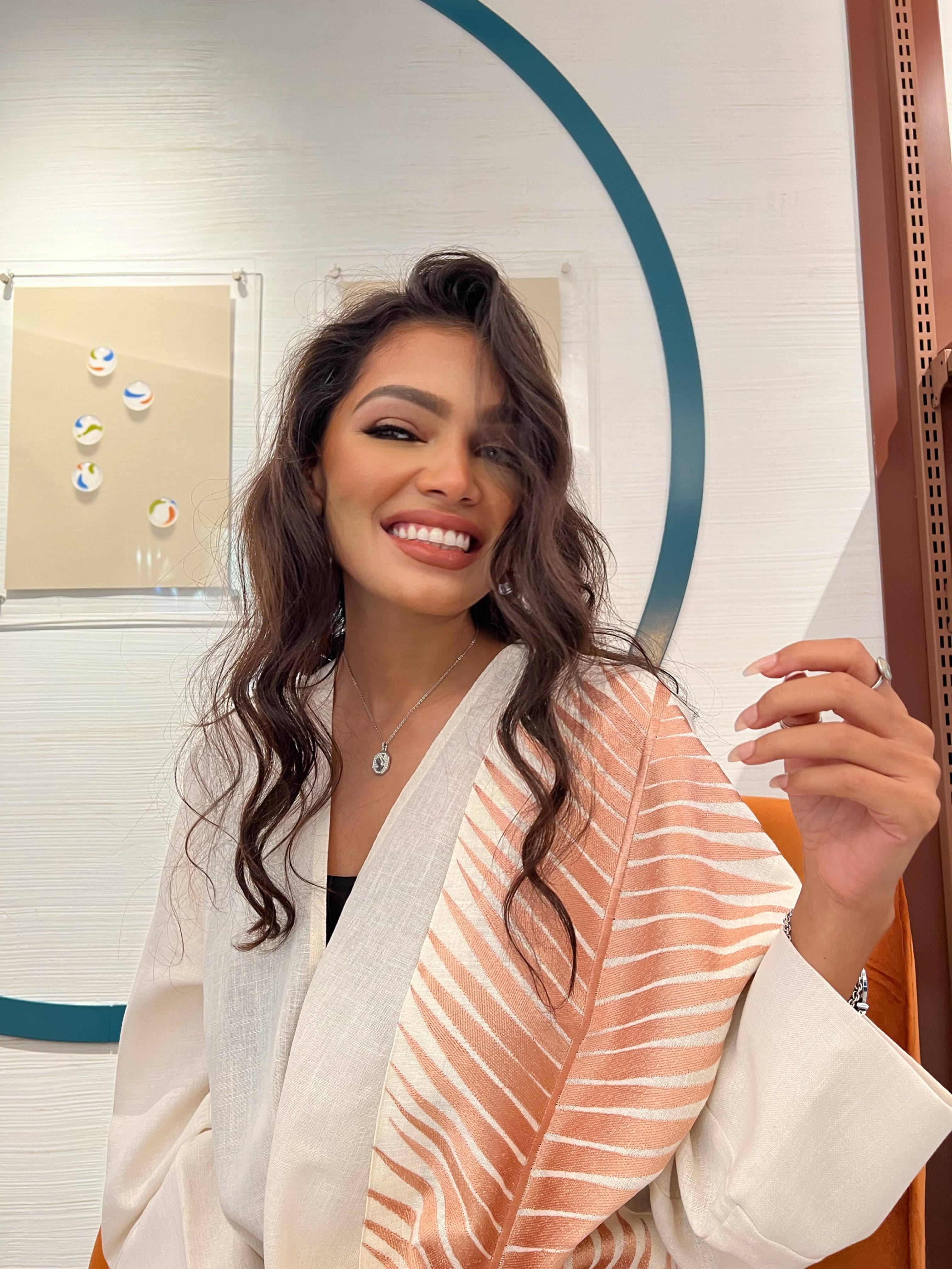 Rosé Gold Abaya - Breast Cancer Awareness | Solidarity, Hope. Smiling model wearing rose gold abaya, promoting breast cancer awareness with elegance.