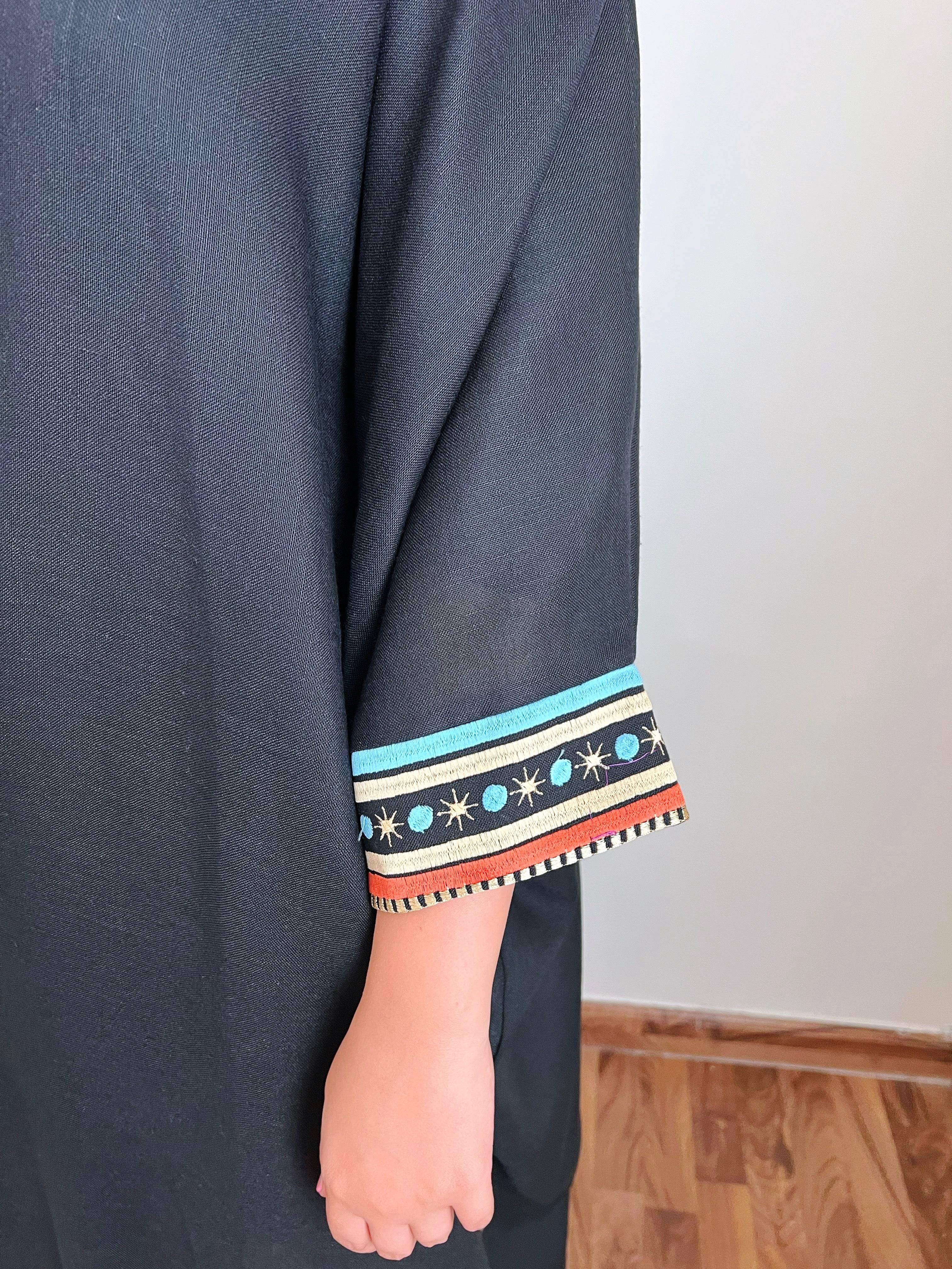 Detailed sleeve embroidery of Distant Galaxies - Show Stopper Back Abaya with stars and planets in blue, orange, and gold tones on black fabric.
