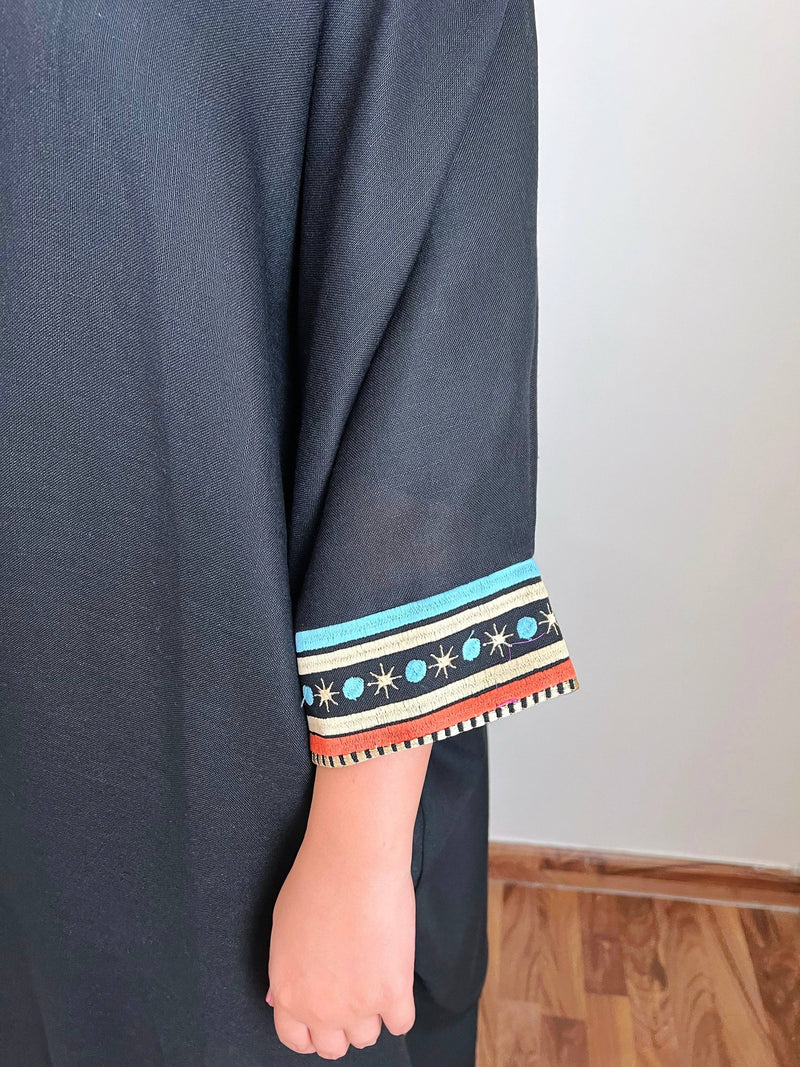 Detailed sleeve embroidery of Distant Galaxies - Show Stopper Back Abaya with stars and planets in blue, orange, and gold tones on black fabric.