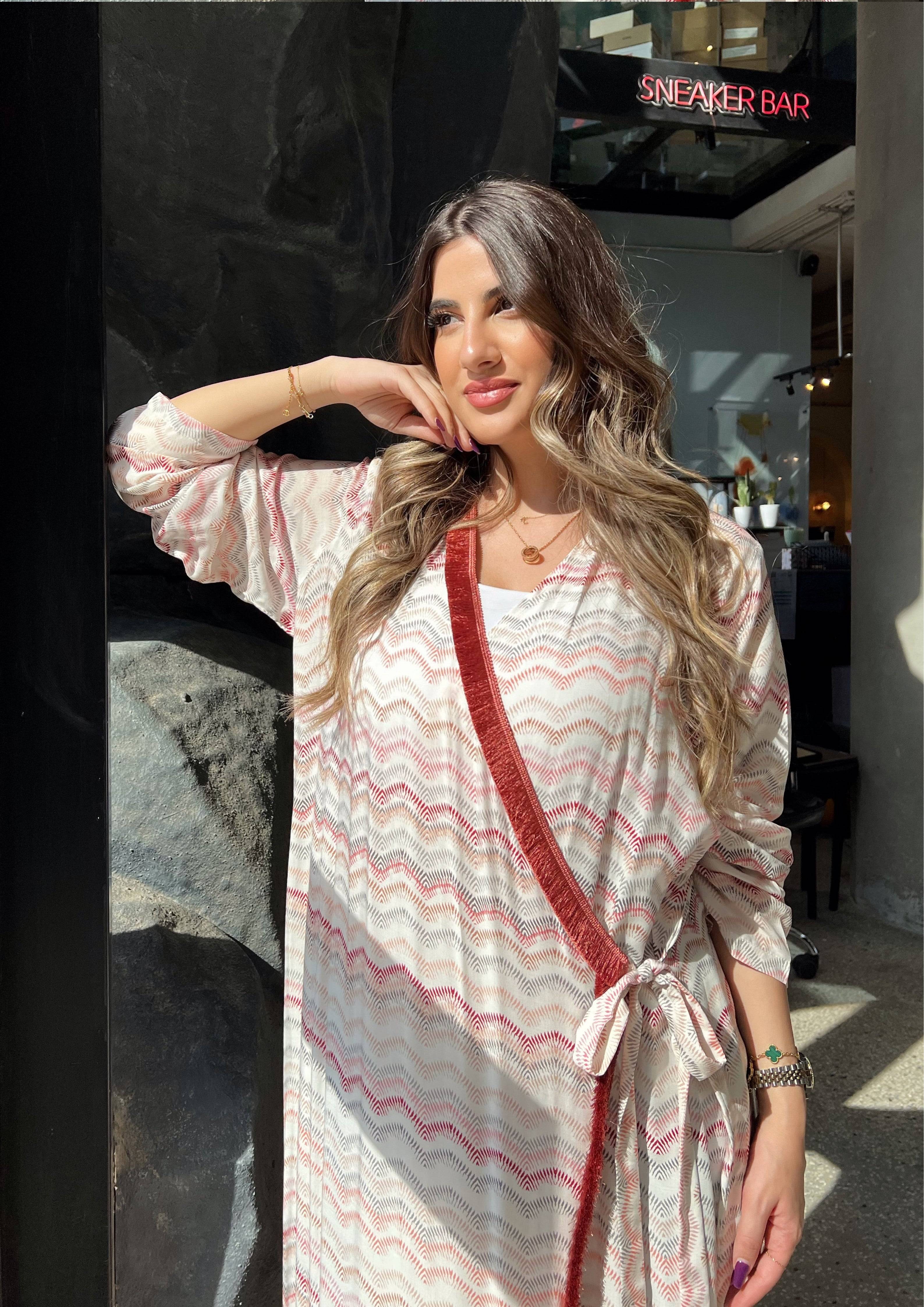 Pink print soft abaya with red velvet trim, styled as a wrap kimono. Made in Saudi Arabia, ideal for modern modest fashion.