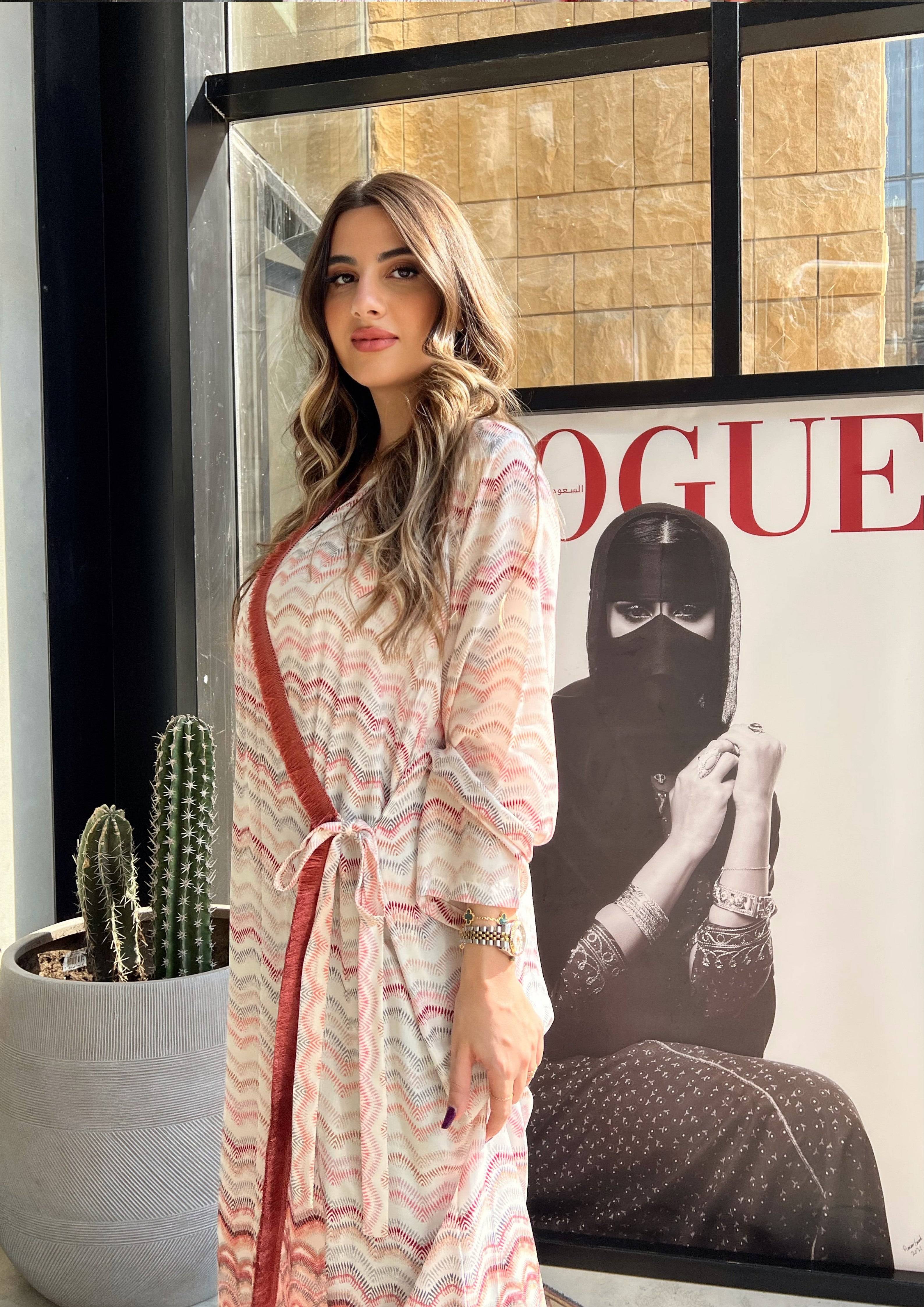 Side view of pink print abaya with red sash and geometric hem. Elegant Saudi wrap kimono for everyday or occasion wear.