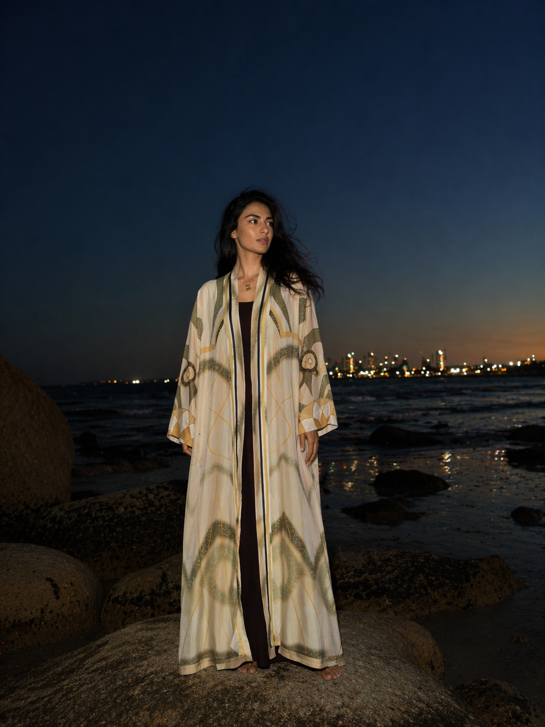 A women wearing a beige printed abaya in a fashion editorial shoot