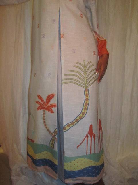 Back view of The Jeddah Horizon - Abaya & Scarf Set with palm tree and wave prints, styled in a neutral indoor setting.