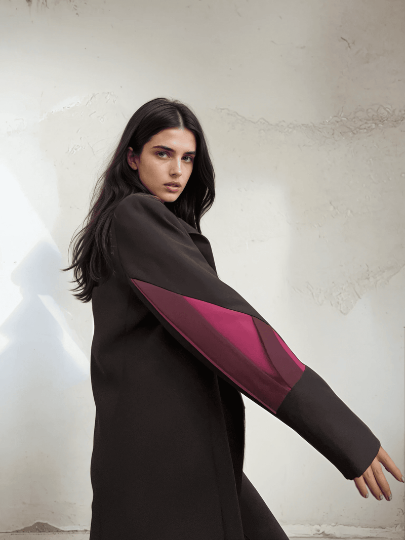 Side profile of The Front Row Feeling - Long Blazer highlighting the vibrant magenta sleeve panels on a structured black coat.