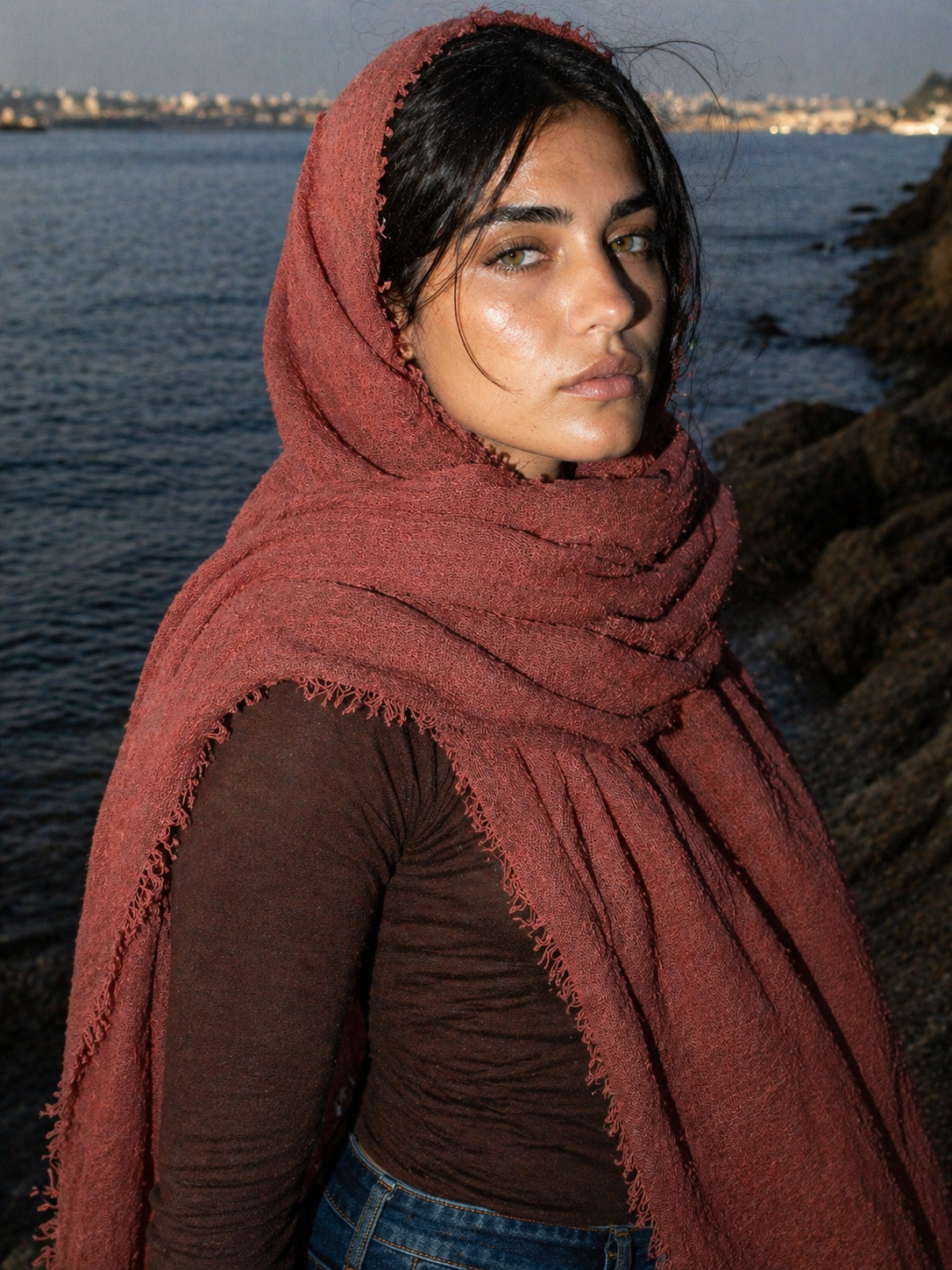 Woman wearing a red scarf by the water