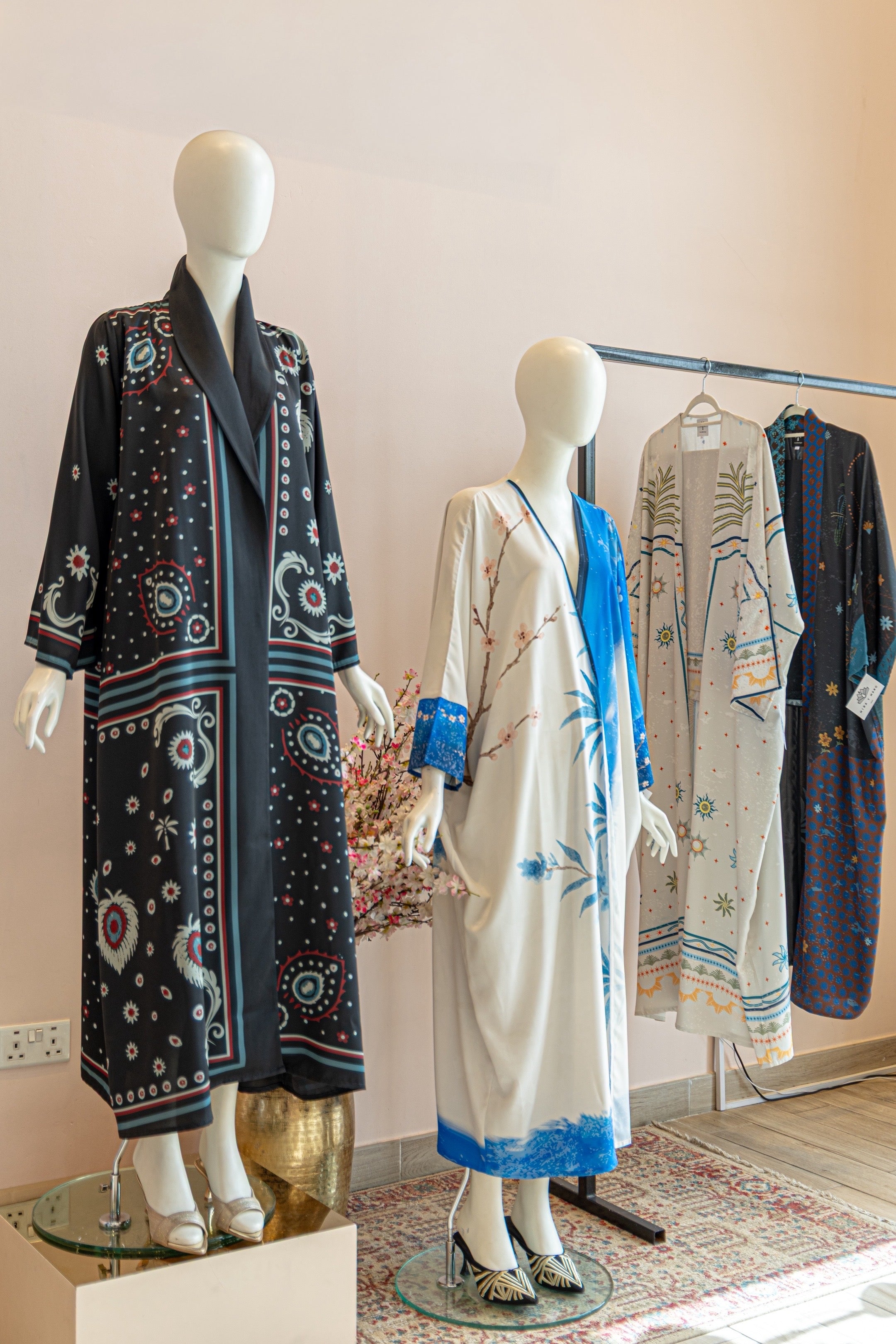 Mannequins wearing patterned dresses in a store setting