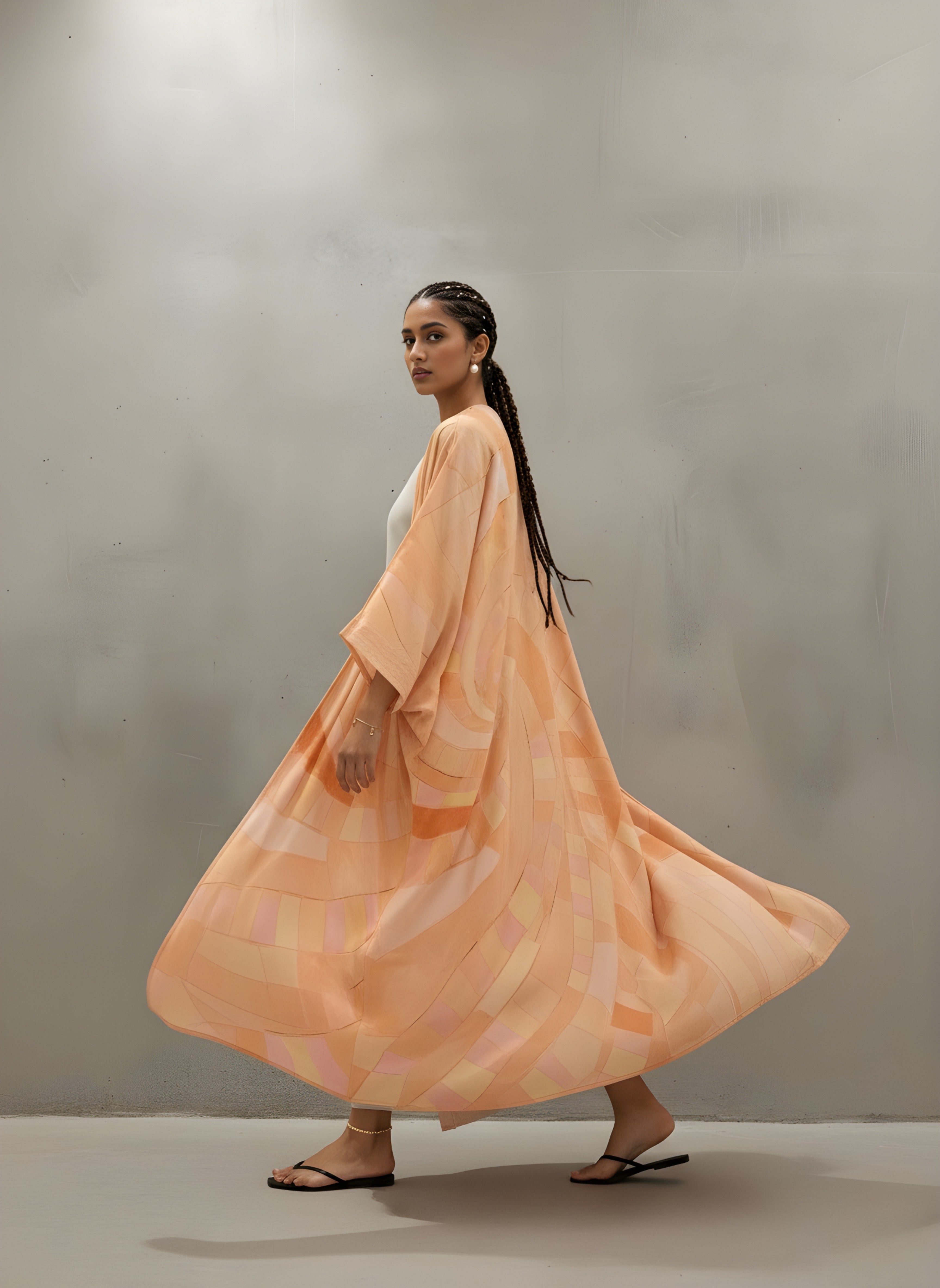 Full-length matte silk abaya in peach with artistic print — sustainable resortwear piece from The Untitled Project.