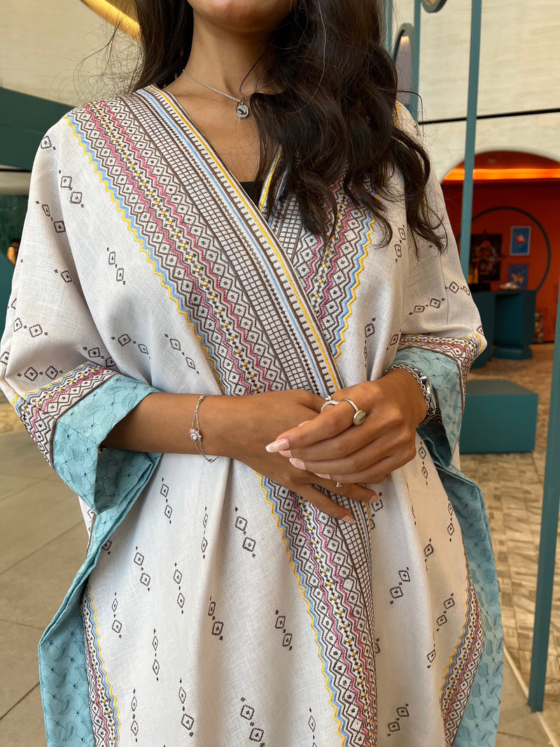 Close-up of hands and chest area in Fatina Abaya showing detailed embroidery and soft fabric texture for a refined look.