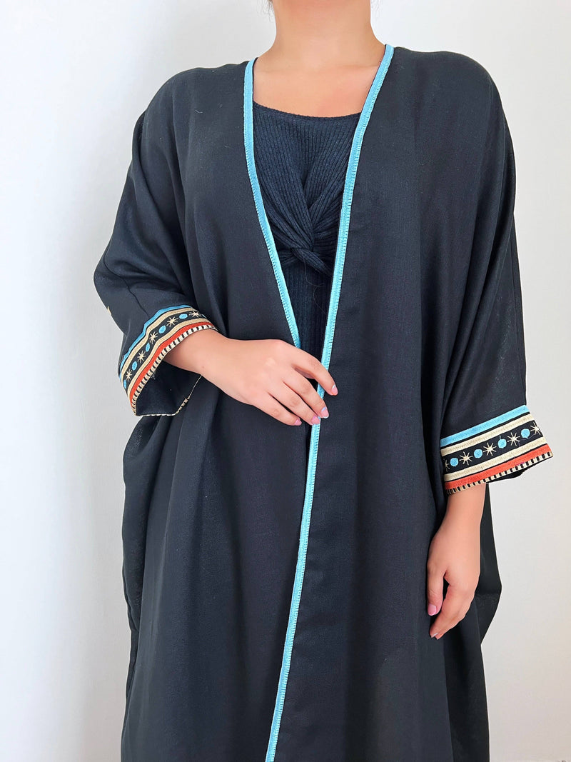 Close-up of Distant Galaxies - Show Stopper Back Abaya front with blue trim and celestial-themed sleeve embroidery, perfect for festive attire.