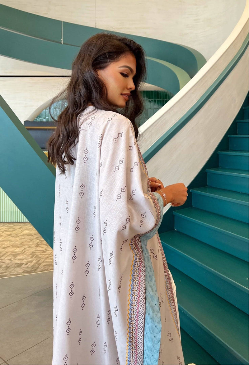 Side profile of model in Fatina Abaya highlighting the soft fabric and detailed embroidery along the sleeves and sides.